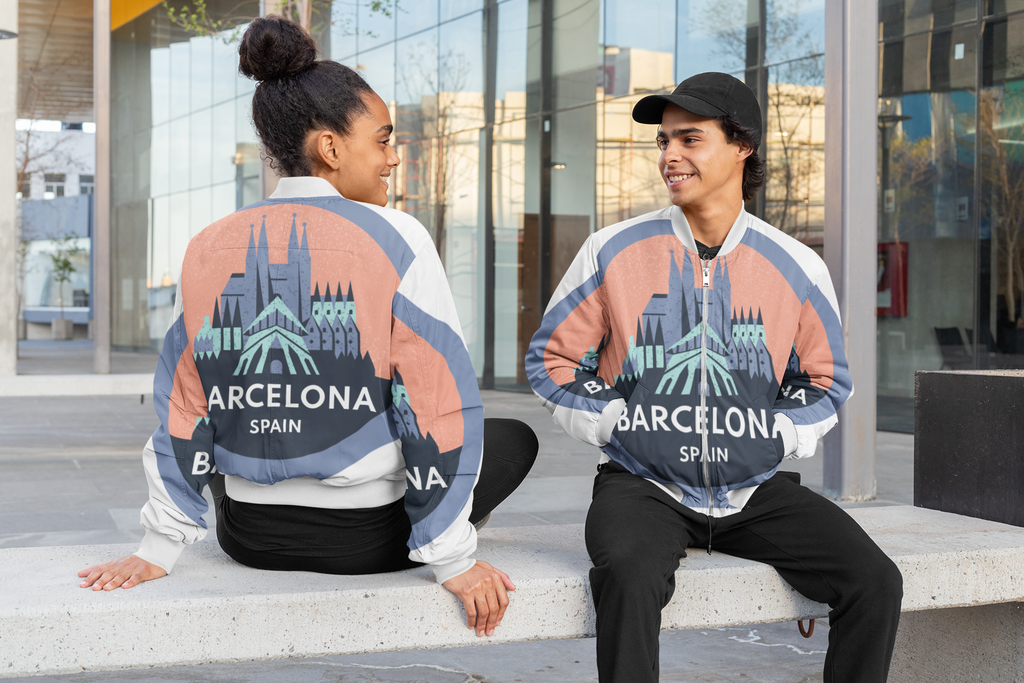 Two people wearing matching sweatshirts with Barcelona, Spain design sitting on a bench.